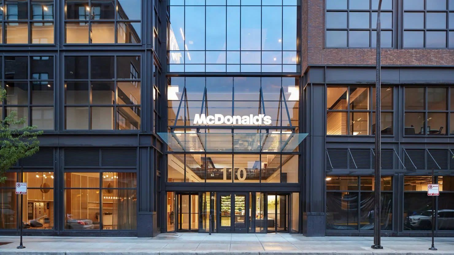 McDonald's global headquarters at dusk — a modern glass building in Chicago's Fulton Market district